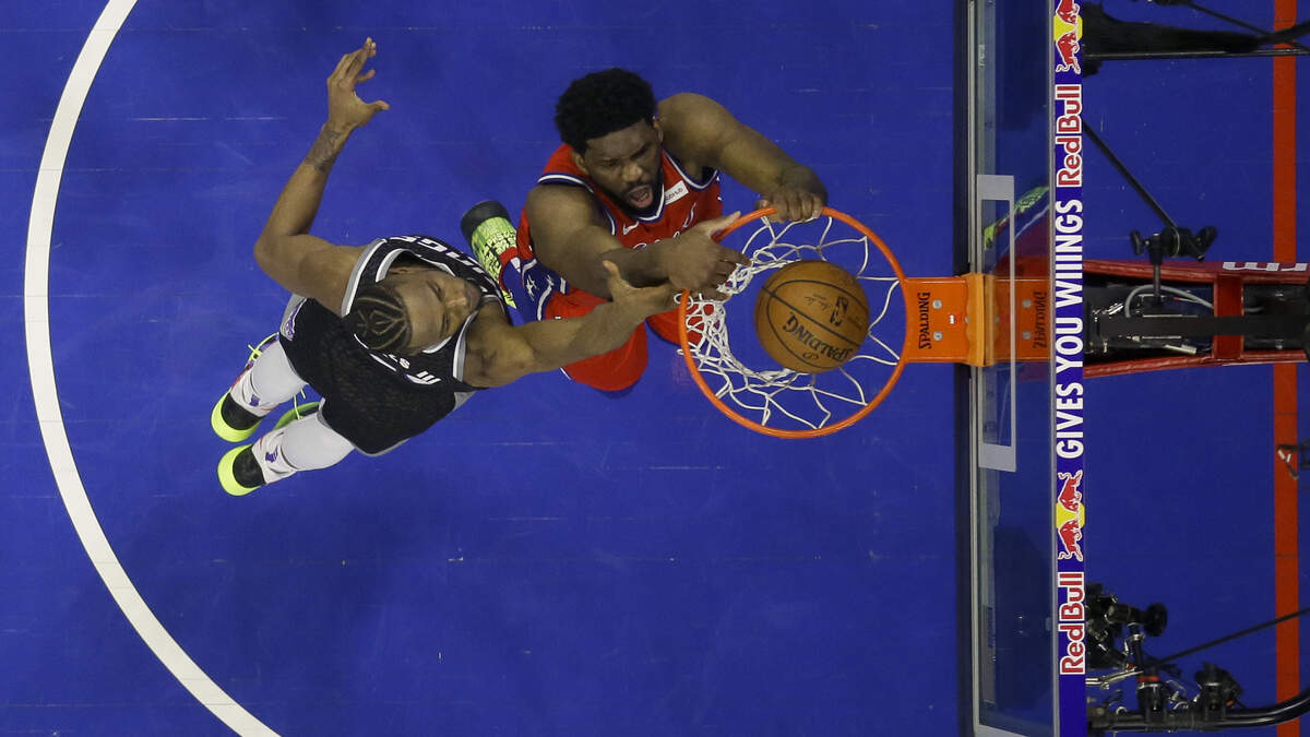 Philadelphia 76ers center Joel Embiid, right, dunks on Kings big man Harry Giles III on Friday in Philadelphia.