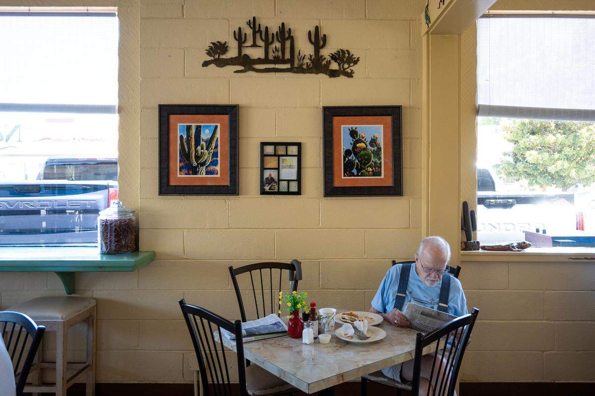 East Sacramento resident Ralph Merrill, 88, reads the newspaper after eating his eggs, bacon and pancakes at Nopalitos Southwestern Cafe in East Sacramento on Aug. 16, 2024.