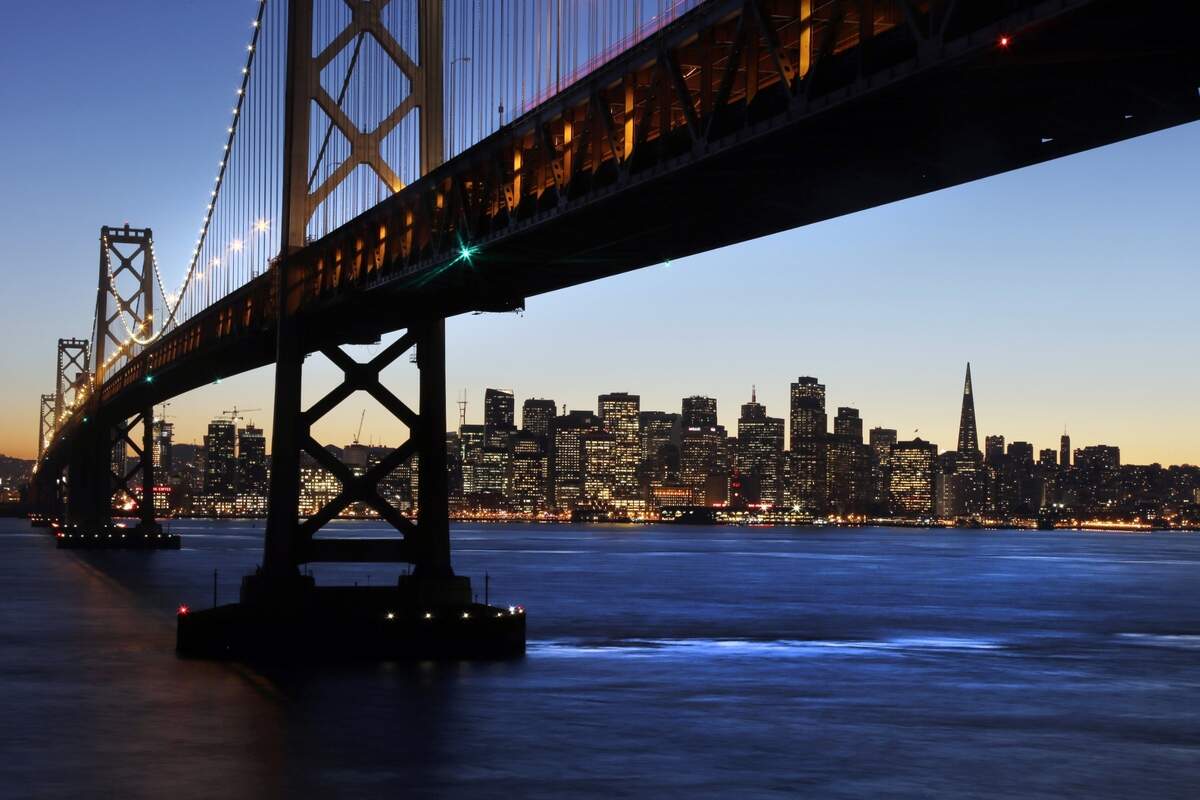 The San Francisco-Oakland Bay Bridge towers over the city skyline at dusk on Wednesday, Jan. 7, 2015, in San Francisco. (AP Photo/Marcio Jose Sanchez)