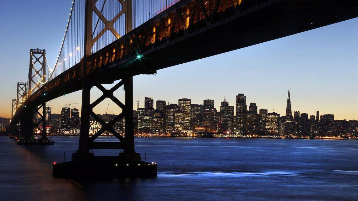 The San Francisco-Oakland Bay Bridge towers over the city skyline at dusk on Wednesday, Jan. 7, 2015, in San Francisco. (AP Photo/Marcio Jose Sanchez)