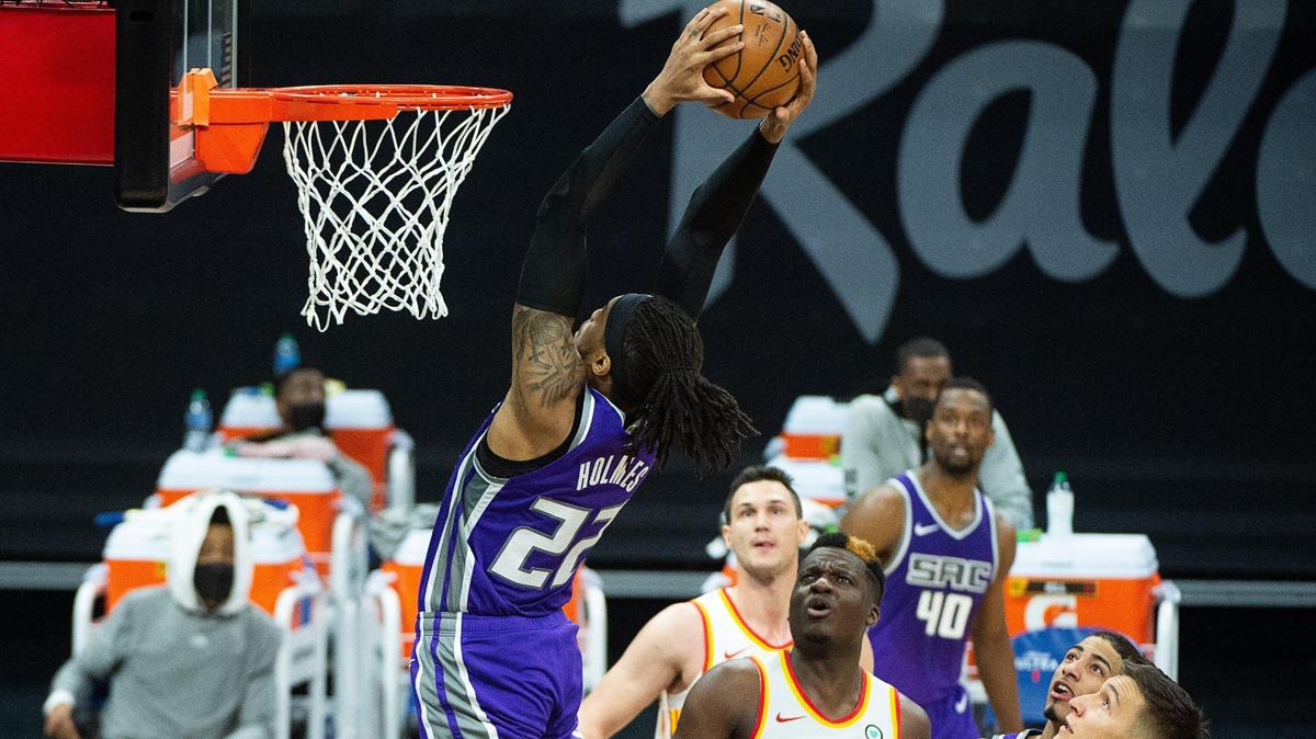 Sacramento Kings center Richaun Holmes (22) dunks the ball over Atlanta Hawks guard Bogdan Bogdanovic (13) and Atlanta Hawks center Clint Capela (15) in the fourth quarter during a game at Golden 1 Center on Wednesday, March 24, 2021 in Sacramento.