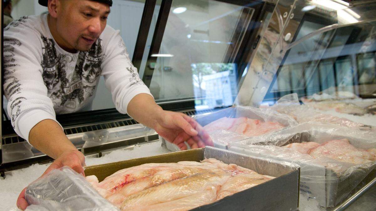 General manager Casey Chandavong places fresh sole into one of Sunh Fish's display cases.