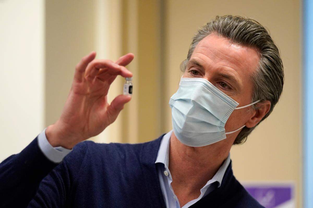 California Gov. Gavin Newsom holds up a vial of the Pfizer-BioNTech COVID-19 vaccine at Kaiser Permanente Los Angeles Medical Center in Los Angeles on Monday, Dec. 14, 2020.