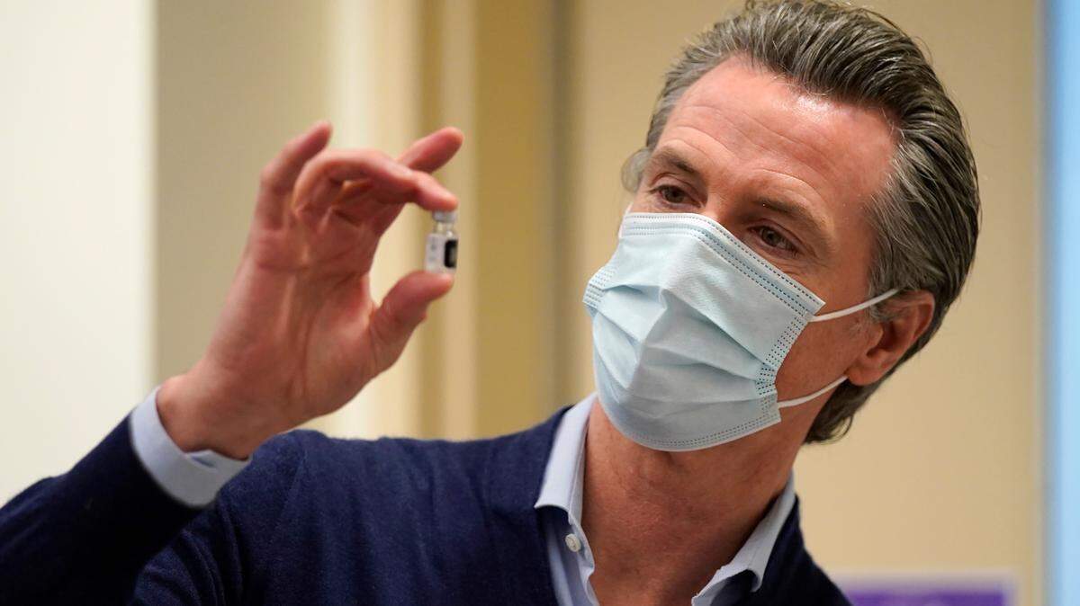 California Gov. Gavin Newsom holds up a vial of the Pfizer-BioNTech COVID-19 vaccine at Kaiser Permanente Los Angeles Medical Center in Los Angeles on Monday, Dec. 14, 2020.