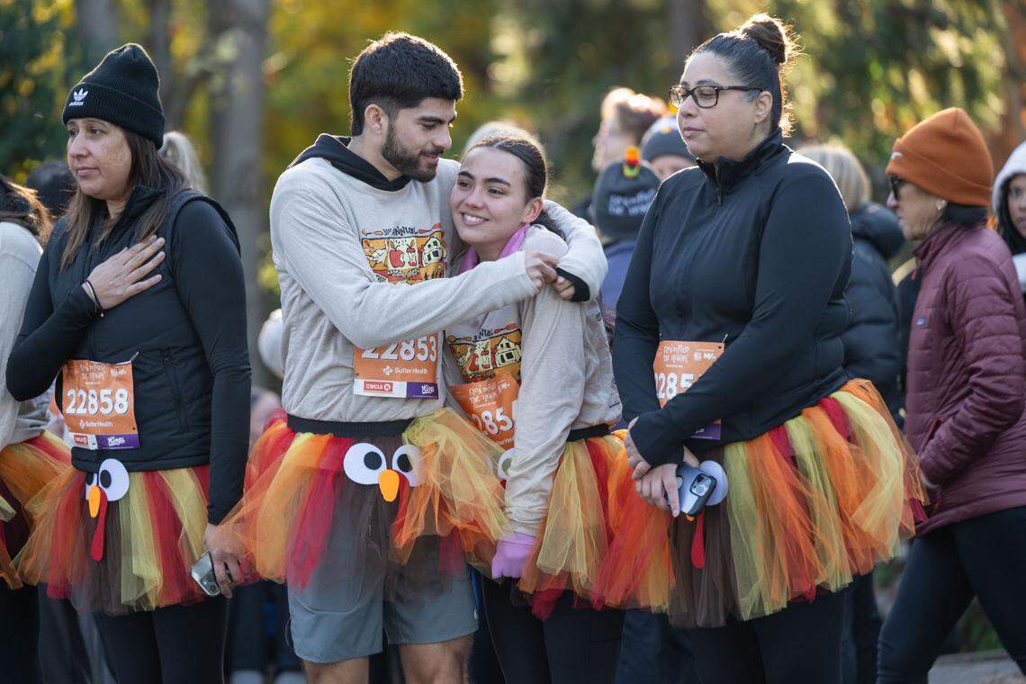 Kenneth Esquivias hugs his girlfriend Angela Granados before they participate in the Run to Feed the Hungry in turkey tutus on Thursday.