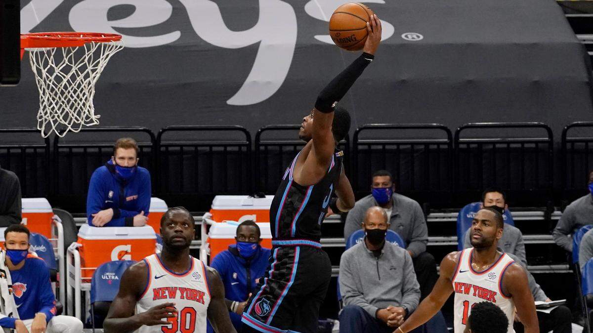 Sacramento Kings guard De’Aaron Fox goes up for the dunk as New York Knicks’ Julius Randle, left, and Alec Burks, right, watch during the second half of an NBA basketball game in Sacramento, Calif., Friday, Jan. 22, 2021. (AP Photo/Rich Pedroncelli)