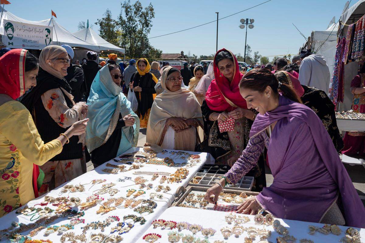 Customers shop with a vendor set-up at the temple during the Sacramento Sikh Society’s first Nagar Kirtan Parade on Sunday, March 26, 2023, at the Sacramento Sikh Society Temple in Vineyard.