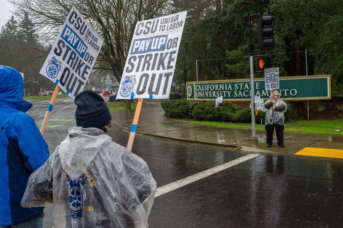 Avery Schick, right, who works in facilities maintenance in the Sacramento State residence halls, joins a Teamsters Local 2010 stike at the university on Tuesday in Sacramento. 
