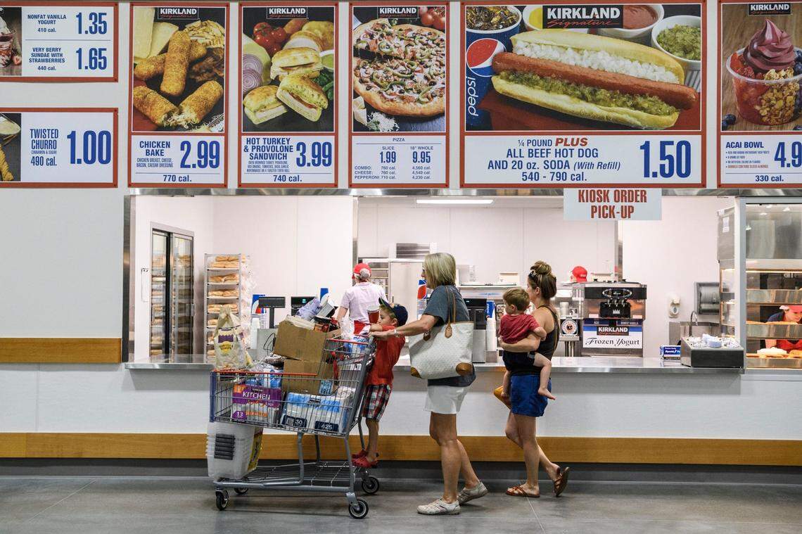 Jaxon Stern, 4, from left, Nicole Toone, Sawyer Stern, 2, and Victoria Stern order lunch at Costco's food court while shopping in the new Evansville store, Friday, June 28, 2019. They ordered a few "famous" $1.50 hot dogs. Costco Opening 18