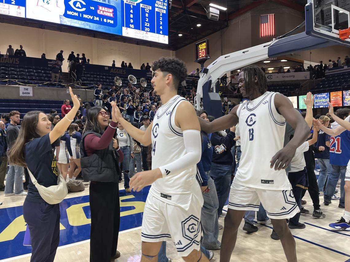UC Davis players celebrate their 77-73 win over Sacramento State on Friday high-fiving fans after the game at University Credit Union Center on the UC Davis campus.
