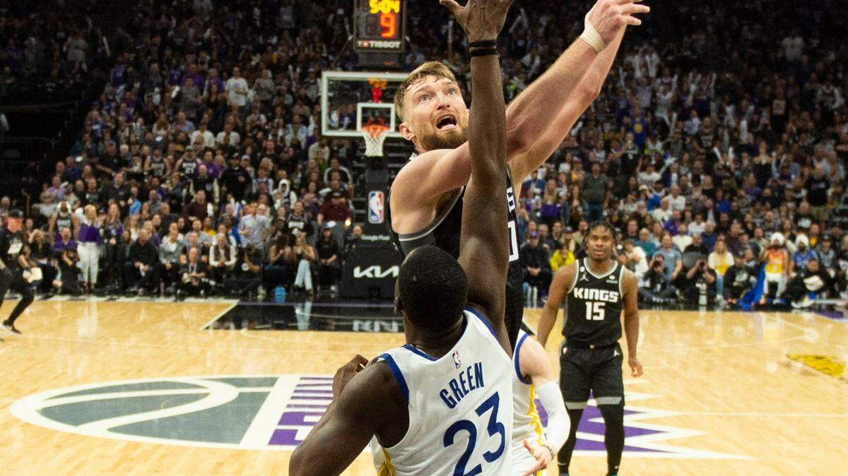 Sacramento Kings center Domantas Sabonis (10) shoots over Golden State Warriors forward Draymond Green (23) during Game 2 of the first-round NBA playoff series at Golden 1 Center on Monday, April 17, 2023.