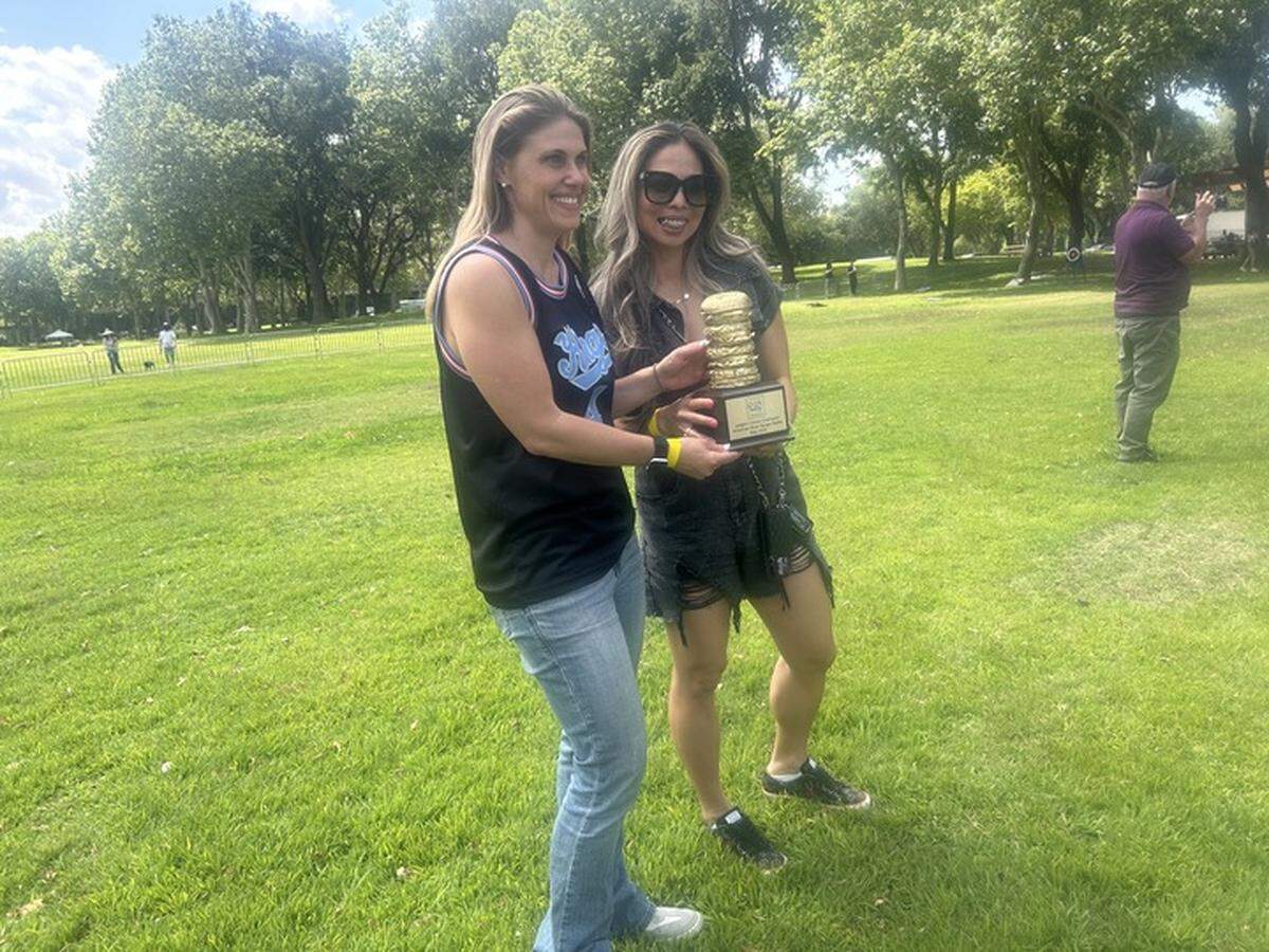 Assemblymember Maggy Krell, D-Sacramento, left, and prominent injury attorney Anh Phoong, right, wait to award a special trophy for the top burger as selected by local celebrity judges at the American River Parkway Foundation’s burger battle at Discovery Park on Saturday.
