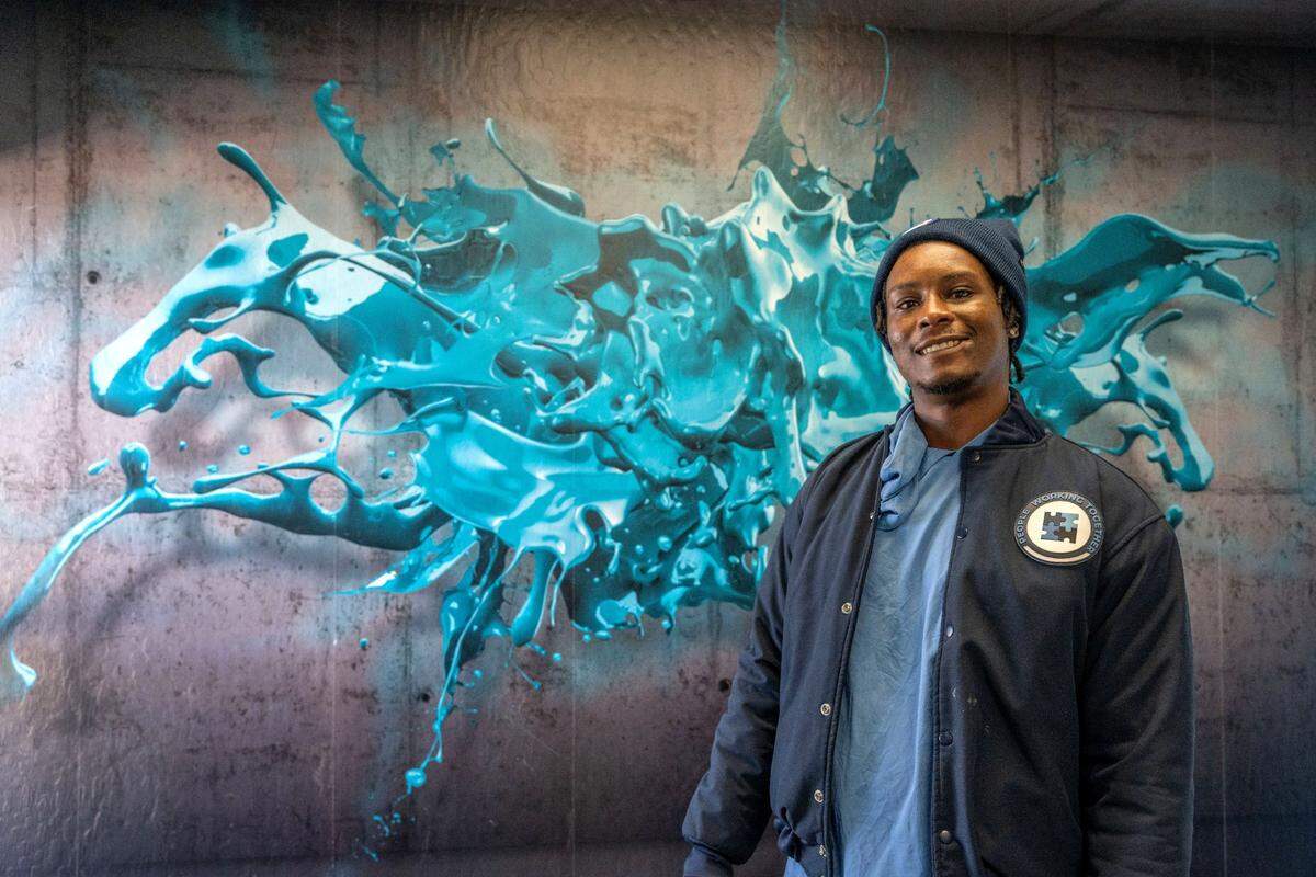 Sidney Randle proudly stands Tuesday, March 25, 2025, in front of a mural he painted while working at People Working Together construction training facility in Sacramento. He said the program helped him make a career in the construction trade. He said he expects to eventually have a contractors’ license and run his own business.