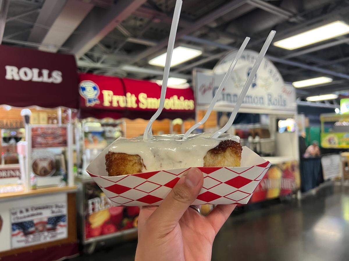 A Sac Bee reporter purchases a cinnamon roll on the State Fair’s opening day.