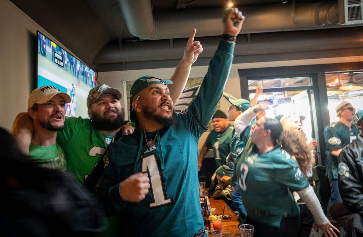 Jessie Jameson, center, an Eagles fan who said he was born in Philly and bleeds green, celebrates a touchdown in the “eagle’s nest” at Limelight sports bar in Sacramento on Sunday. The Eagles are heading to the Super Bowl after defeating the Washington Commanders 55-23 in the National Football Conference.