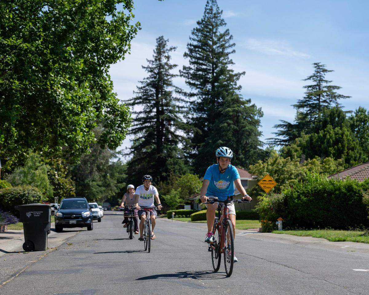Alena Wong and her parents Kevin and Taryn Wong cycle on Mead Avenue in Land Park on June 18. Four years ago, Alena Wong was hit by a car as she rode her bike to school, through the intersection of Sutterville Road and Mead Avenue in Sacramento in October 2019.