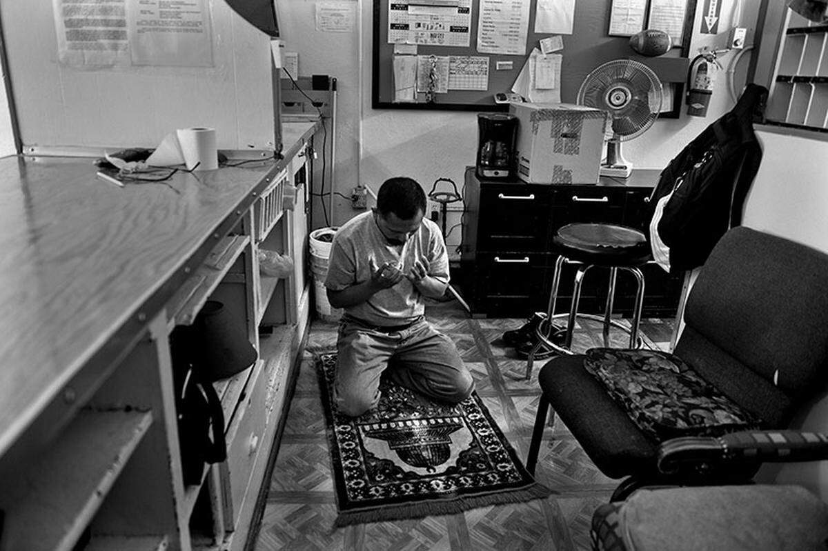 Mannan Viloria, 52, kneels on the prayer rug behind his desk in the lobby of the Hotel Marshall, a ritual he engaged in several times a day. “We’ll see what comes,” he said of the hotel’s closing. “I don’t fear anything but God.”