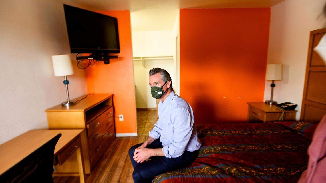 California Governor Gavin Newsom sits on a bed while touring Bella Vista Inn, a hotel which is being converted to interim housing for the homeless, on Thursday, Jan. 13, 2022, in Santa Clara, Calif.