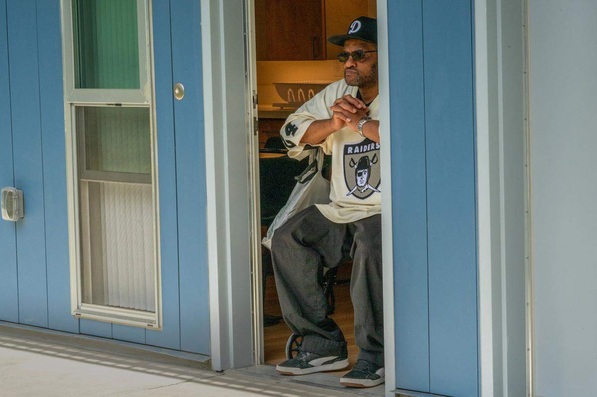 Resident Dewayne McDaniel watches from the doorway of his apartment as dignitaries speak at the grand opening of Northview Pointe, a 67-unit permanent supportive housing development for people experiencing homelessness in North Sacramento, on Wednesday.