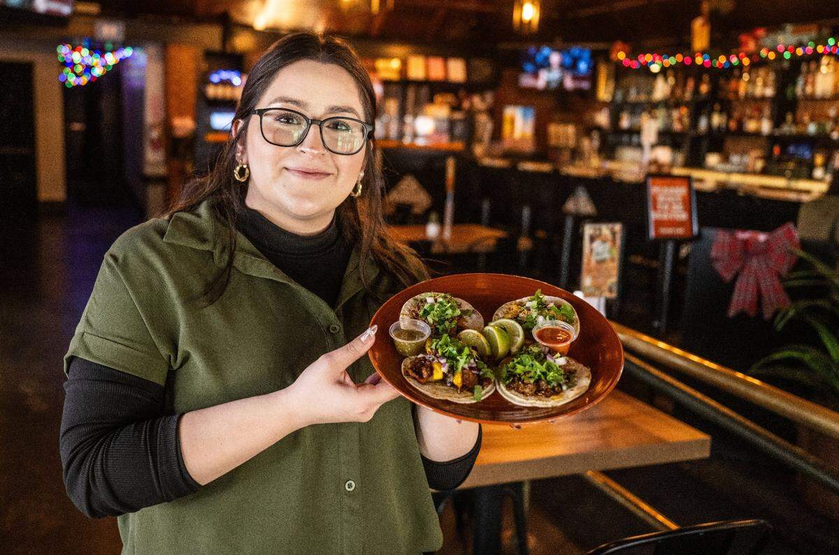 Evaleen Nambo, co-owner of Thirtyfour Mexican Cantina, holds tacos at her restaurant last month. The cantina has all-you-can-eat service on Fridays, rare for Mexican cuisine but in keeping with an ongoing dining trend according to food influencer Cassandra Ng.