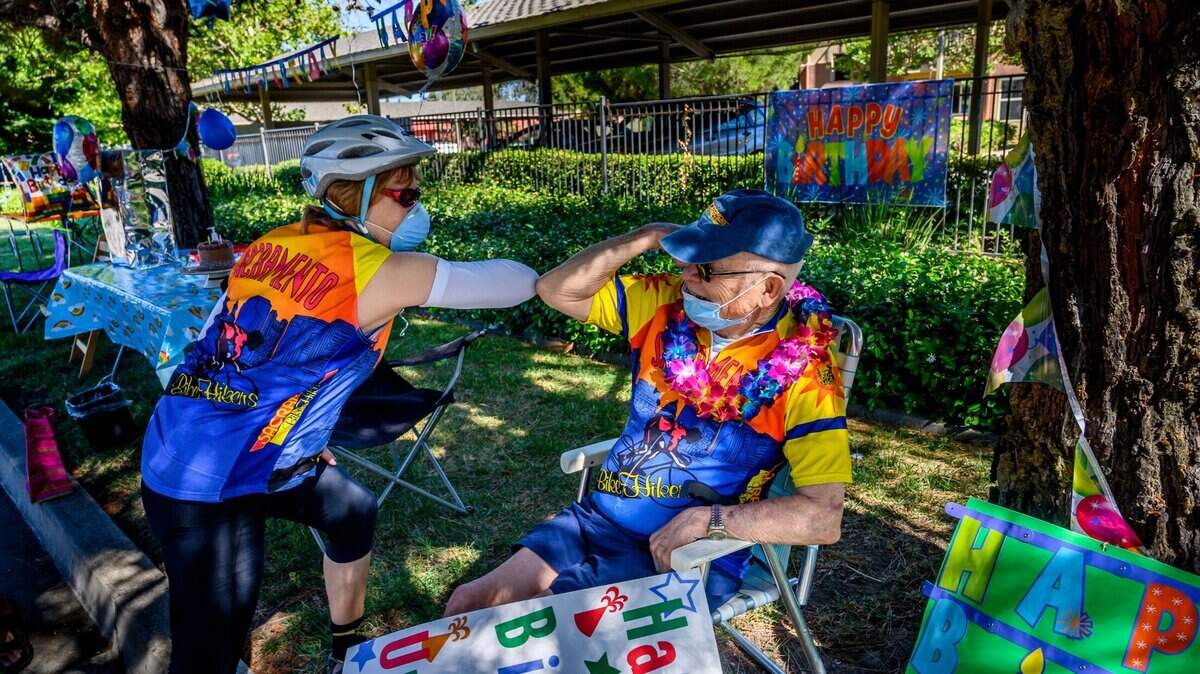 Masayuki Hatano greets a friend with his elbow during his 92nd birthday party in Sacramento, Tuesday, June 9, 2020.
