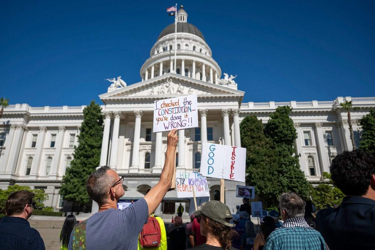 Tim Sobol holds a sign on the west steps of the state Capitol during the “Good Trouble” protest in Sacramento on Thursday. The protest, in opposition to President Donald Trump is named after former Rep. John Lewis and his legacy of activism.