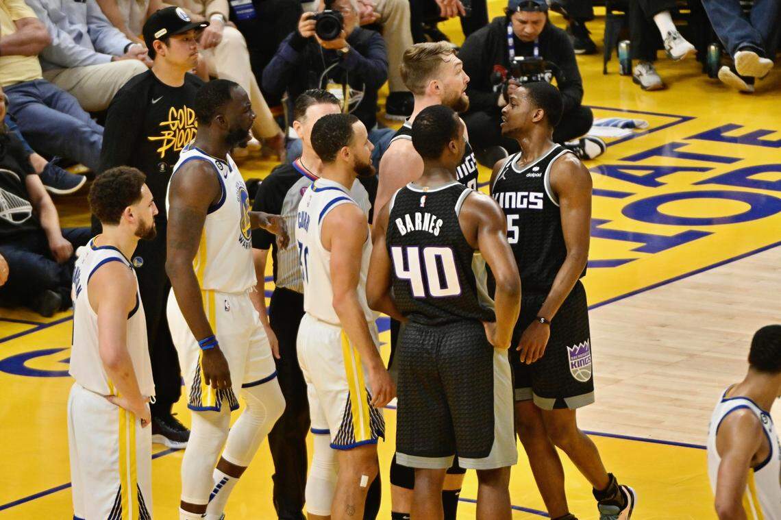 Sacramento Kings guard De’Aaron Fox and Golden State Warriors forward Draymond Green exchange words during the first quarter of Game 4 of the first-round NBA playoff series at Chase Center in San Francisco on Sunday.