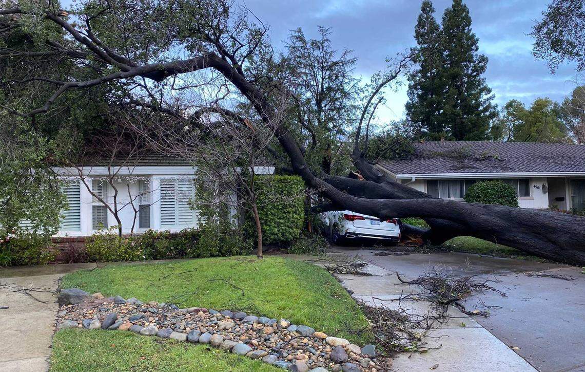 A fallen tree rests on an Acura MDX and part of a home’s roof in Carmichael in 2024. A strong storm brought strong winds to the Sacramento region on Sunday, whipping trees and downing power lines across the capital region.