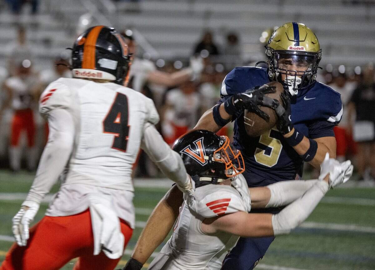 The West Park Panthers’ Topher Petersen (5) makes a catch as Vacaville Bulldogs' Jake Williams (5) defends In the second half on Friday in Roseville.