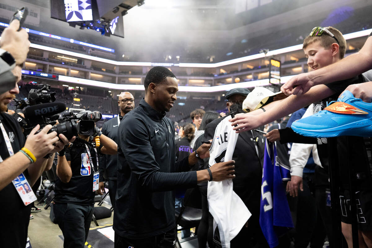 San Antonio Spurs guard De’Aaron Fox (4) signs autographs before he makes his way to the locker room before an NBA game against the Sacramento Kings on Friday.