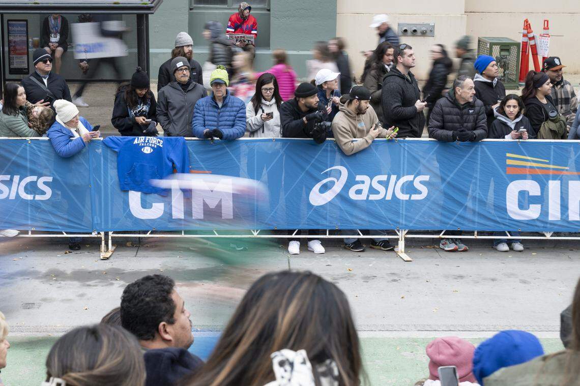 Spectators watch runners participate in the California International Marathon in Sacramento on Sunday, Dec. 7, 2025.