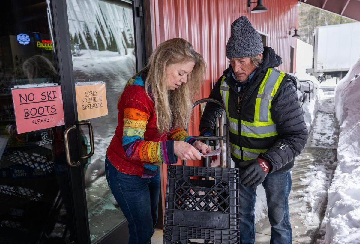 Cheryl Paduano, owner of Soda Springs Store, reviews an order with Ben Holder after he made a delivery earlier this month. Paduano said she never closed her store during the recent blizzard because she knew customers would be needing supplies.