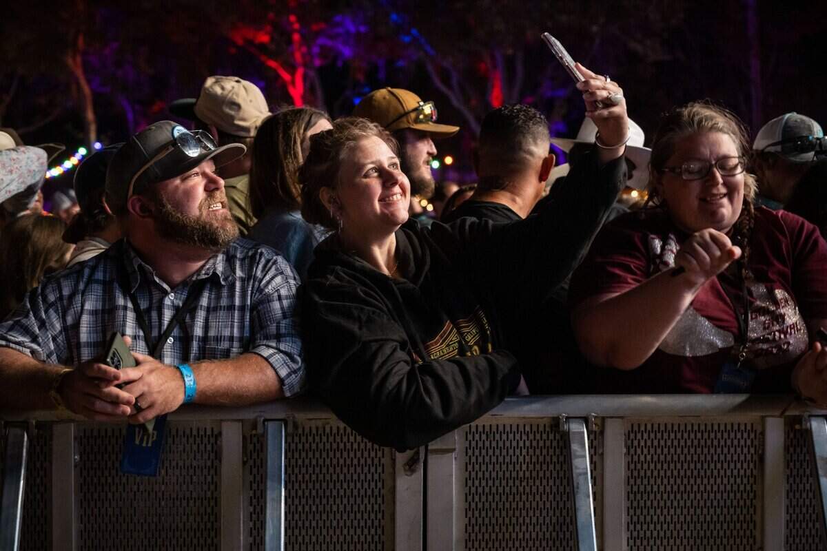 Darcie Bumpass, of Yosemite, takes a selfie while waiting for Tim McGraw to take the Jack Daniels Stage, as Tabatha Stone of Anderson dances at right, at Sacramento’s first-ever GoldenSky country music festival Saturday, Oct. 15, 2022, at Discovery Park. The two-day event featured headliners Tim McGraw and Sam Hunt, as well as Brothers Osborne, Midland, Carly Pearce and more.