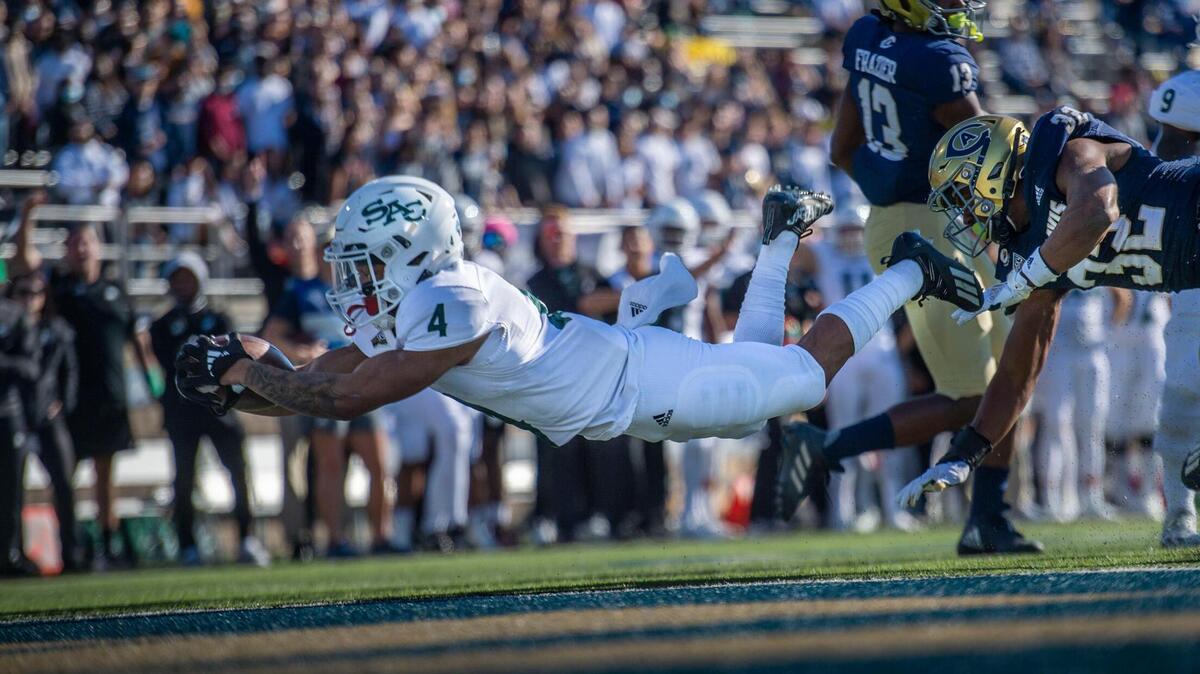 Sacramento State Hornets wide receiver Isaiah Gable (4) scores a touchdown as he’s defended by UC Davis Aggies defensive back Erron Duncan (32) on Saturday, Nov. 20, 2021, during the Causeway Classic football game at UC Davis Health Stadium in Davis.