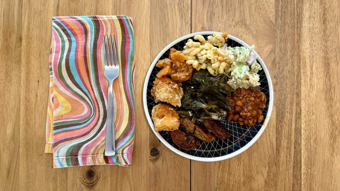 Vegan versions of hot links and fried chicken from Bay Area-based food truck Vegan Mob are served alongside candied sweet potatoes, greens, slaw, beans and “Smackaroni” on Sunday, April 12, 2026 in Sacramento.