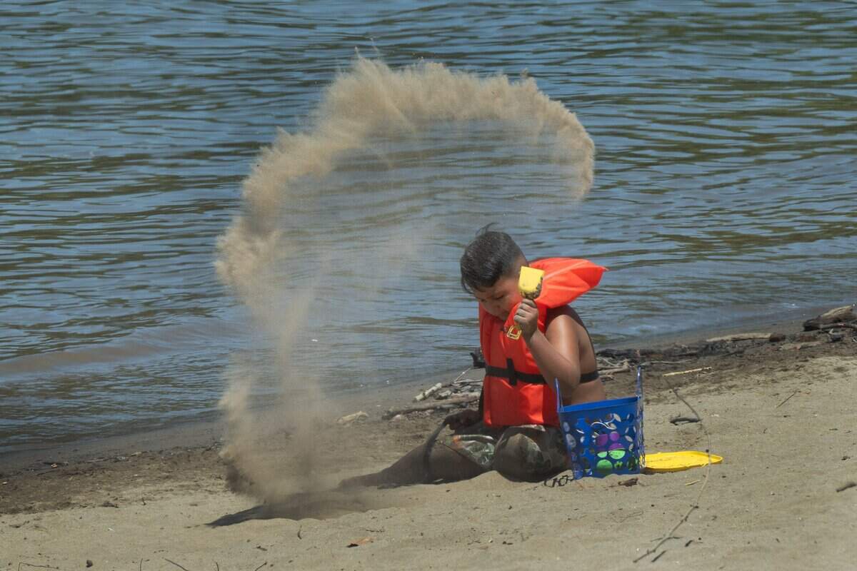 Claudio Garcia, 6, of Sacramento wears a life jacket while playing in the sand at Sacramento's Tiscornia Beach along the American River on July 3. The park provides free life jackets for children.
