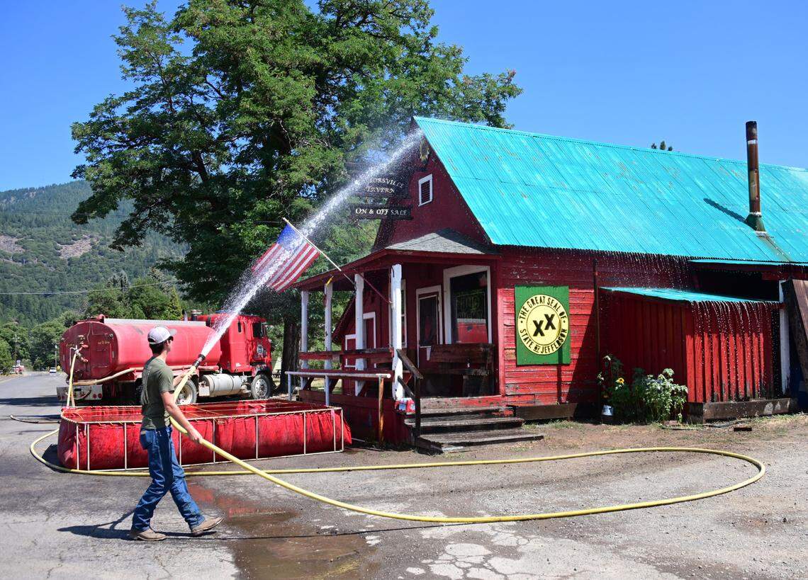 Greenville resident Colt Beres hoses down the Taylorsville Tavern as the town was under an evacuation order on Thursday, Aug. 5, 2021.