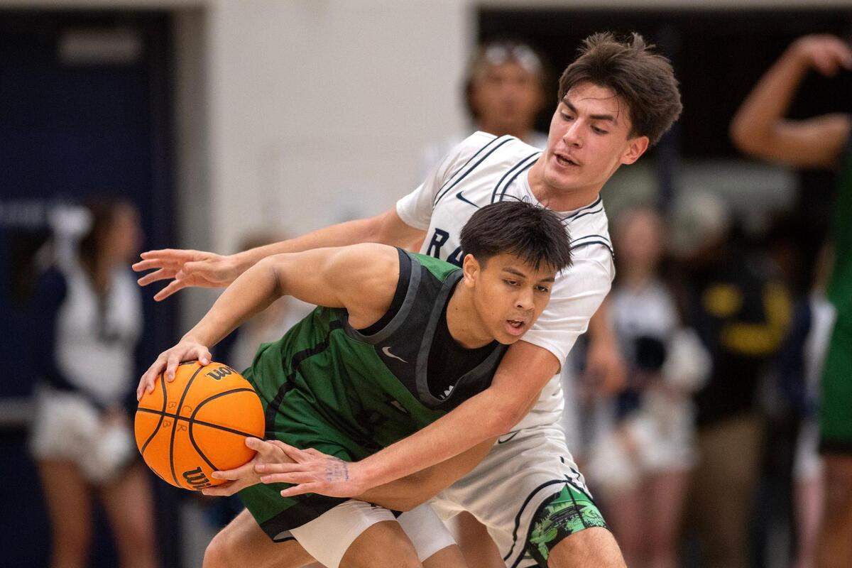 The Casa Roble Rams’ Benny Ambriz (22) defends the Twelve Bridges Raging Rhinos’ Derek Baltazar (4) in the first half of a CIF Northern California Division IV boys basketball playoff game Tuesday, March 4, 2025 in Orangevale.