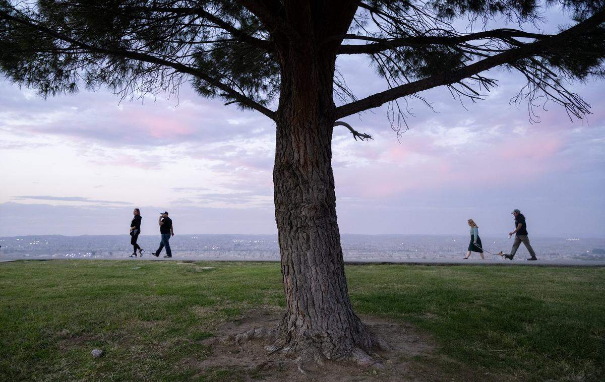 Residents walk above the Kern River Oil Field on their evening walk in Panorama Park in Bakersfield earlier this month. 