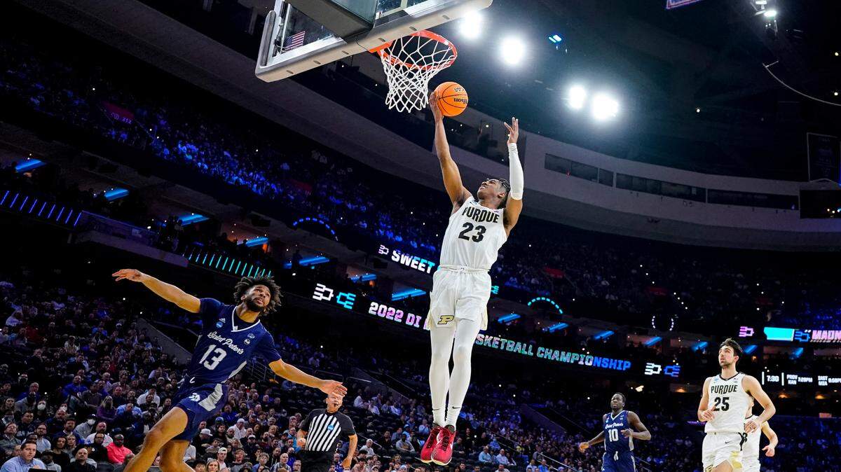 Purdue ‘s Jaden Ivey, center, goes up for the shot as Saint Peter’s Isiah Dasher, left, looks on during the first half of a college basketball game in the Sweet 16 round of the NCAA tournament, Friday, March 25, 2022, in Philadelphia. (AP Photo/Chris Szagola)
