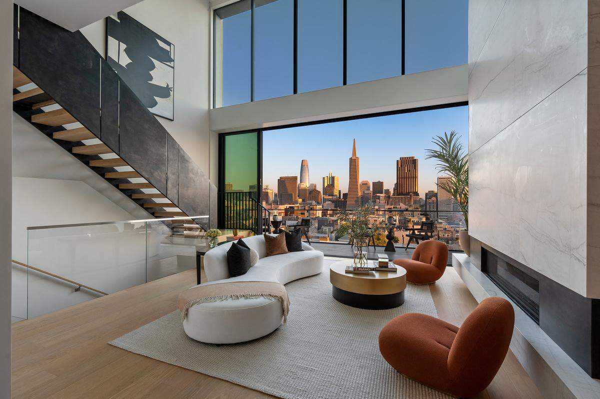 Sophisticated architectural design by Lewis Butler meets contemporary amenities, with oversized windows, a massive living room fireplace, and an airy chef’s kitchen overlooking the city skyline.