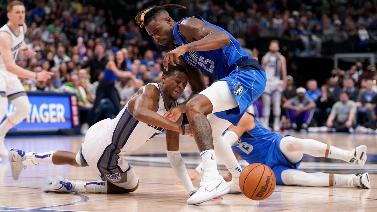 Sacramento Kings guard De’Aaron Fox (5), Dallas Mavericks forward Reggie Bullock (25) and Jalen Brunson (13) scramble on the court floor for control of a loose ball in the second half of an NBA basketball game in Dallas, Saturday, March, 5, 2022. (AP Photo/Tony Gutierrez)