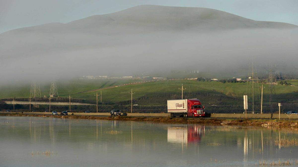 Traffic on Highway 37 passes Sears Point in January 2022. The two-lane section of the highway through this marshland is the focus of a widening project that does not include long-term protections against rising seas.