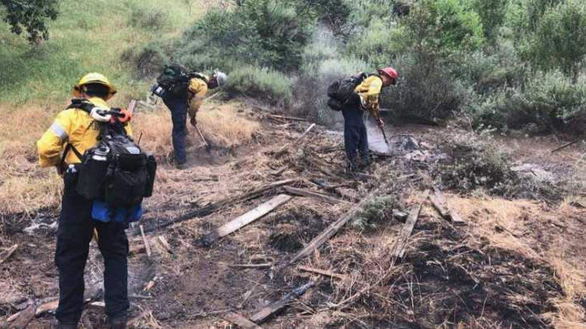 Ventura County firefighters extinguish a small fire sparked by lightning in the foothills around Simi Valley on Sunday.