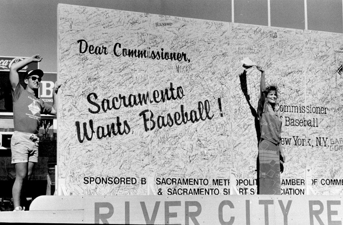 Miss Sacramento Kay-Josselyn Boyle stands in front of an 8-foot by 16-foot "postcard" with over 40,000 signatures during as more than 20,000 Sacramento-area baseball fans attend an Athletics game on Aug. 23, 1987, at Oakland Coliseum to advocate for a Sacramento MLB team. Organizers planned to deliver to the object to Commissioner Peter Ueberroth's office in New York. 