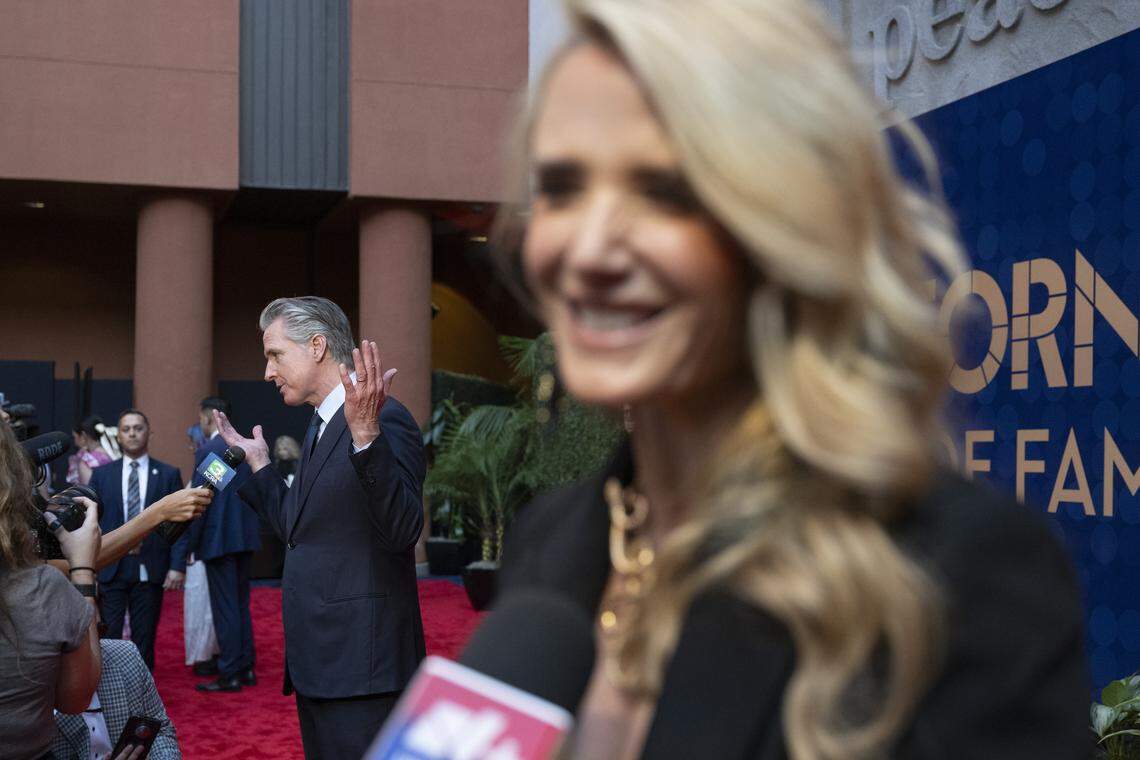 El gobernador Gavin Newsom y la First Partner Jennifer Siebel Newsom responden preguntas de los medios en la alfombra roja antes de la ceremonia de inducción de la 19ª clase de inductees del California Hall of Fame en el California Museum en Sacramento el jueves.