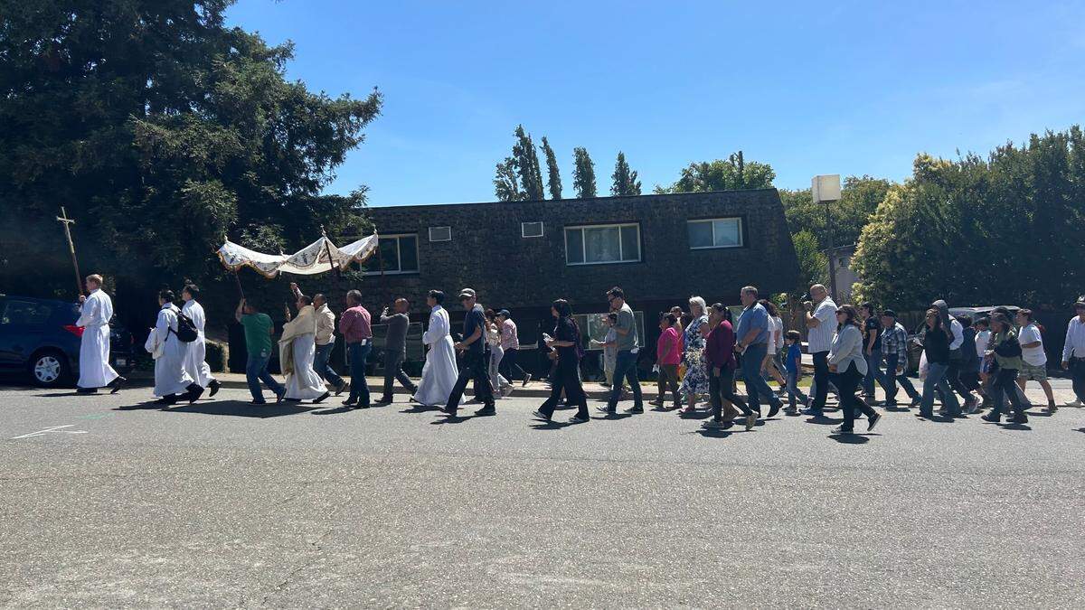 Parishioners and clergy from St. Anthony’s Church march through Walnut Grove on Friday. The group walked to the nearby marina where Deacon Kevin Staszkow waited aboard the Aurora V.