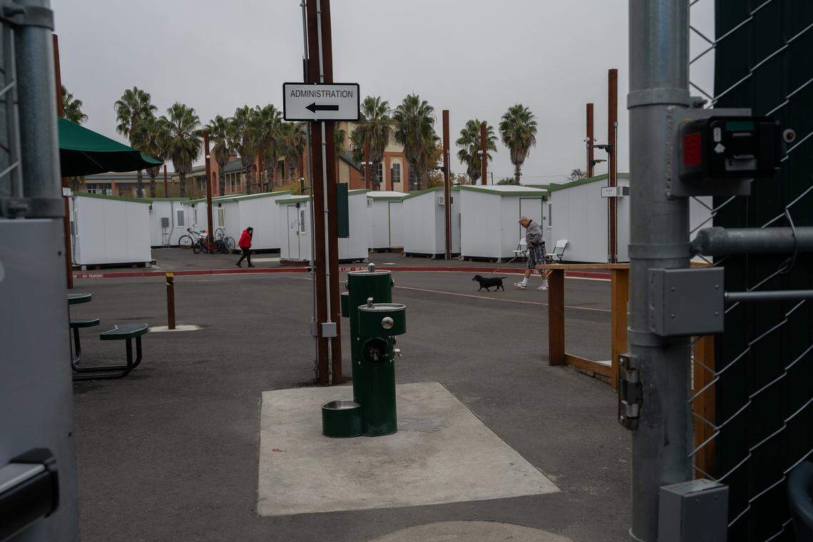 A view of tiny homes through the security door at Sacramento County’s Stockton Boulevard Safe Stay Community in December. The shelter offers shared spaces for laundry, meals, showers, case management, mental health/substance abuse help, and job/housing assistance, plus services for pets. 