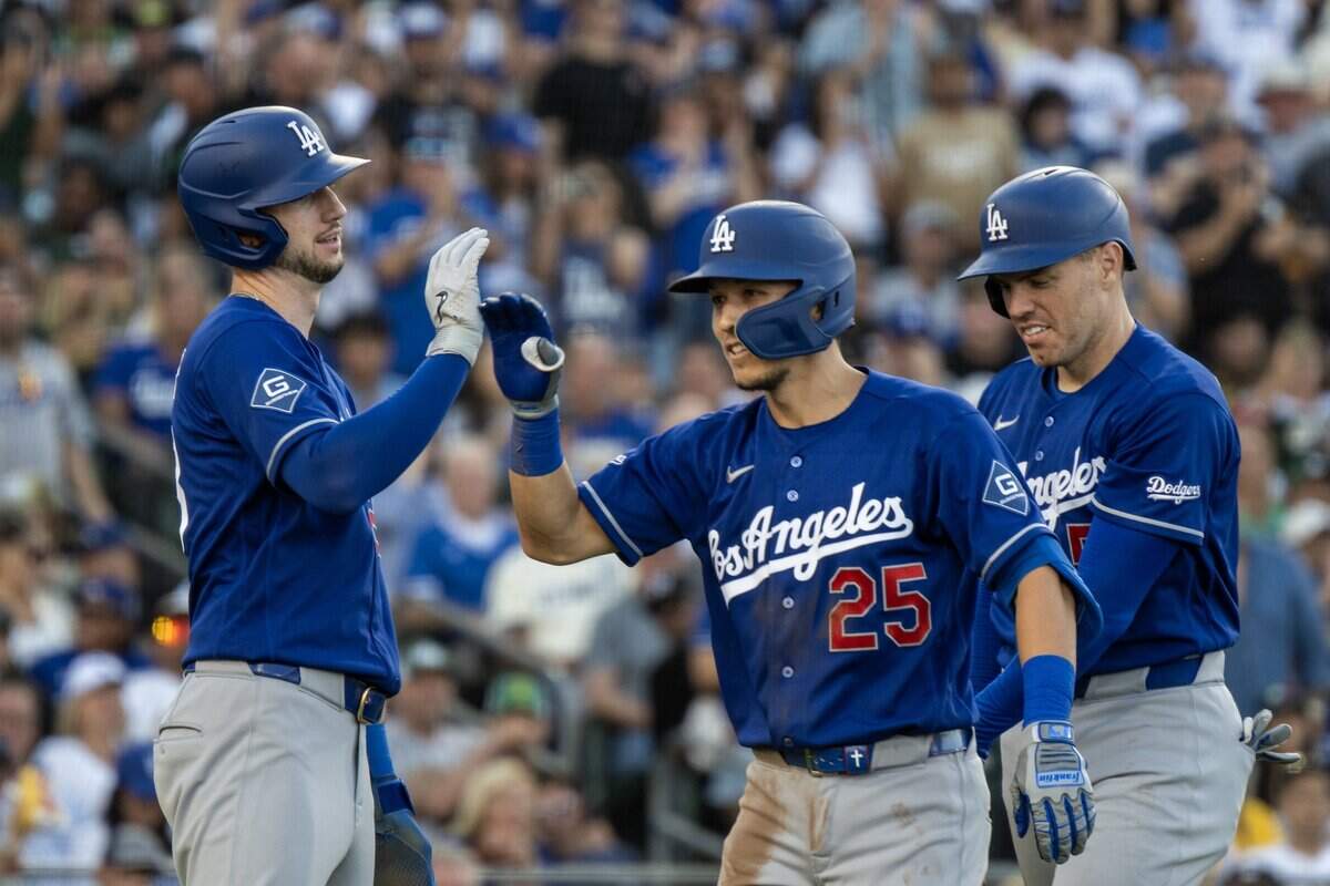 Los Angeles Dodgers hitter Tommy Edman (25) is met by Freddie Freeman (5) and Kyle Tucker (23) after hitting a three-run home run against Athletics pitcher Jeffrey Springs in top of the third inning at Sutter Health Park on Tuesday in West Sacramento.