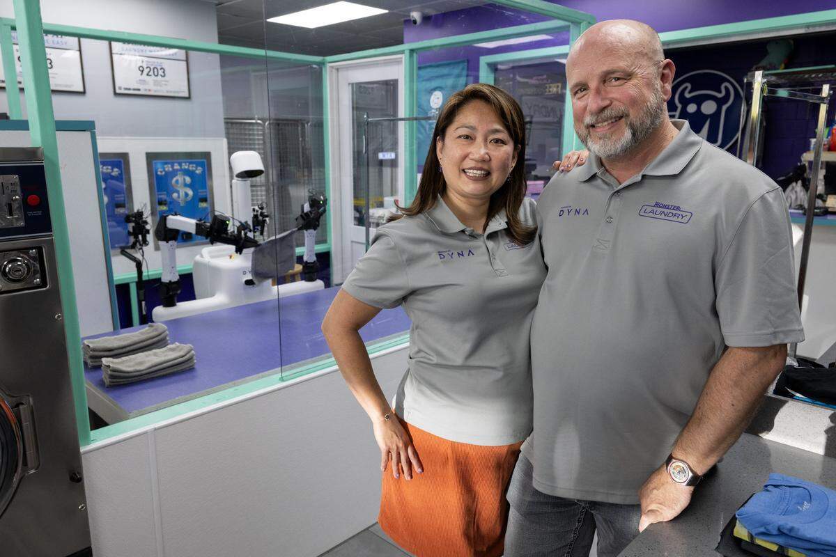 Monster Laundry owners Craig Taylor, right, and Michelle See debut a robotic folding system from Dyna Robotics, named Sophy Swiftfold, on Friday, Sept. 12, 2025, in Sacramento. The AI-powered system will be able to fold towels, linens and clothing.